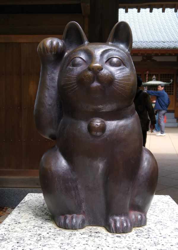Bronze cat sculpture at a Japanese shrine