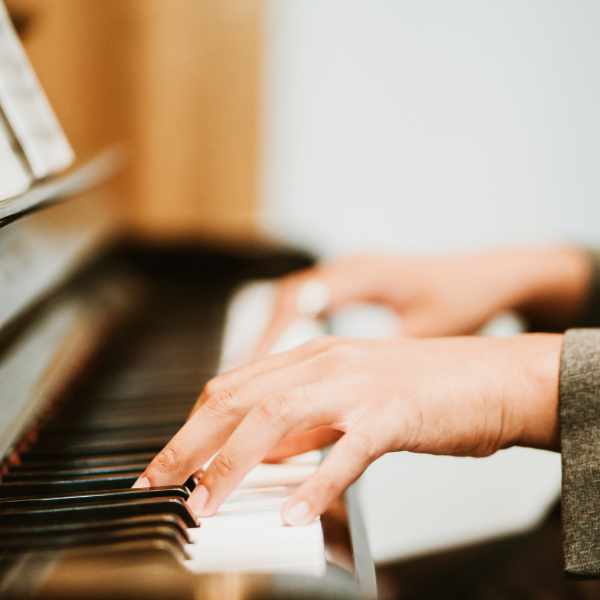 Hands playing piano keyboard