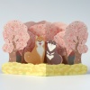 Pop up greetings card with shiba inu dogs sitting under pink cherry blossom trees