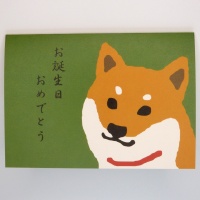 Shiba inu dog character and Japanese birthday greeting on the front of the card