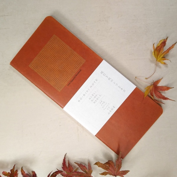 Ro-biki brown-red Japanese notebook on desk with autumnal leaves