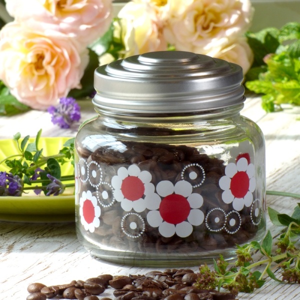 Red and white floral storage jar filled with coffee beans