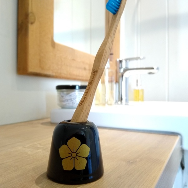 Black 'Akechi' family crest toothbrush holder on bathroom surface