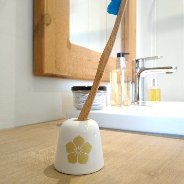 White 'Akechi' family crest toothbrush holder on bathroom surface