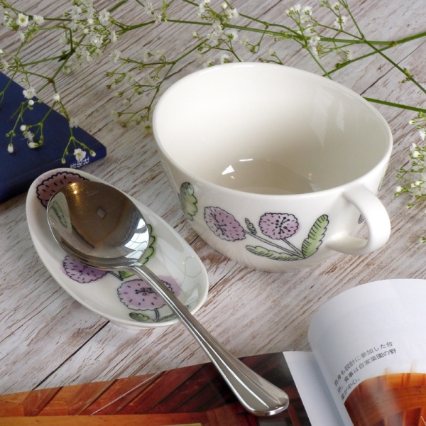 Purple aster floral design soup cup and spoon rest on table