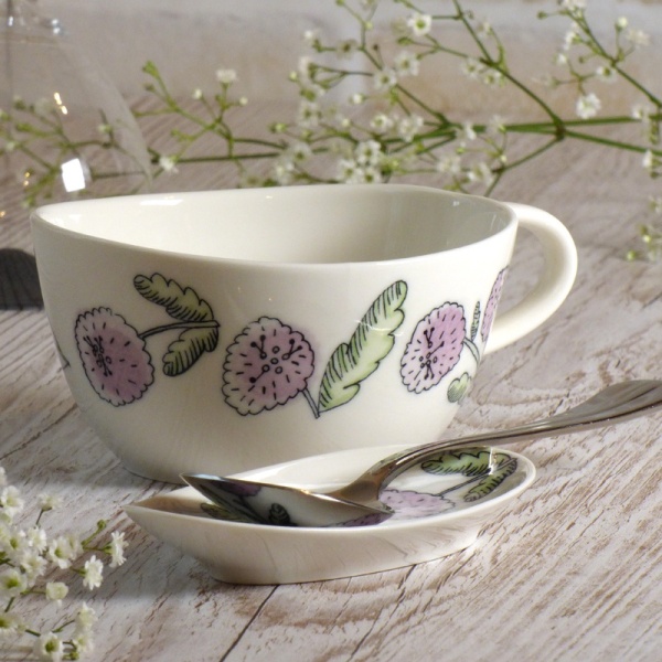 Purple aster floral design soup cup and spoon rest on table