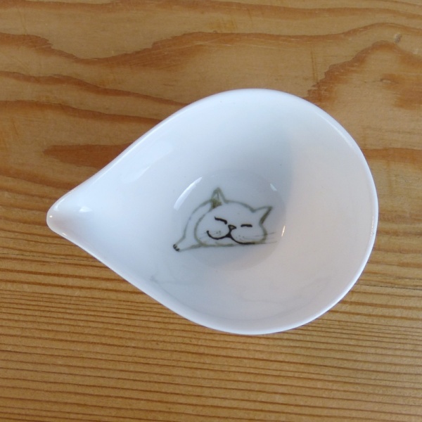 Small white milk jug inside cat decoration