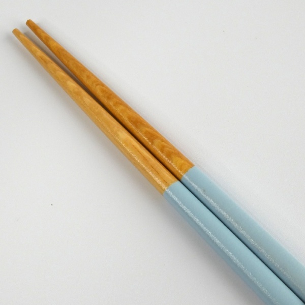Close up of wooden tips of pastel blue chopsticks