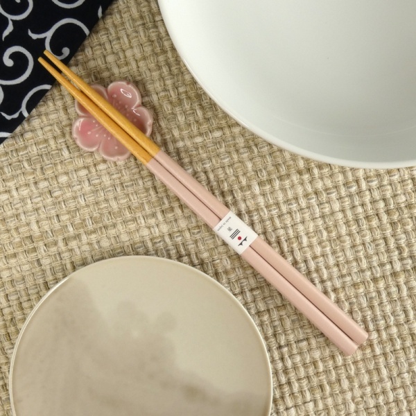 Pastel pale pink chopsticks and chopstick rest on minimalist table setting