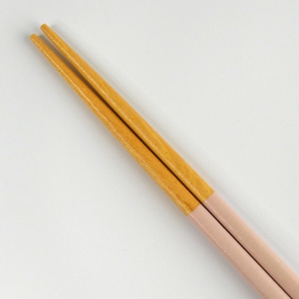 Close up of wooden tips of pastel pink chopsticks