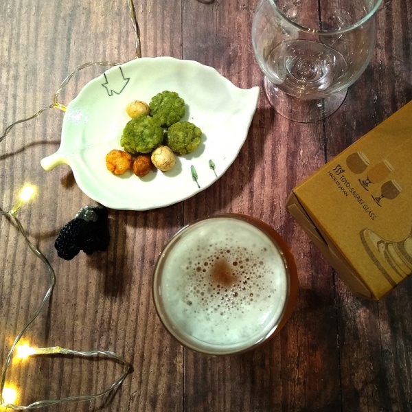 Beer glass on bar next to snacks