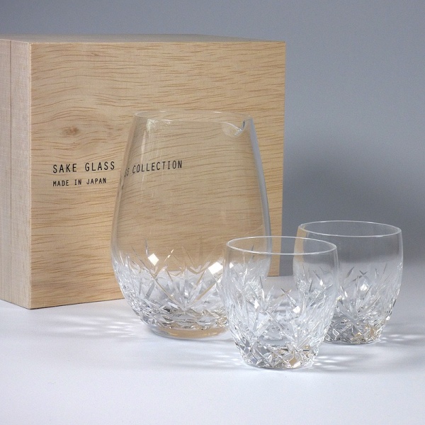 Cut glass sake set, with a jug and two glasses, next to wooden gift box
