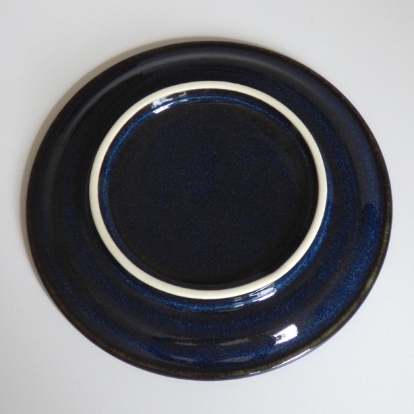 Underside of dark blue ceramic saucer