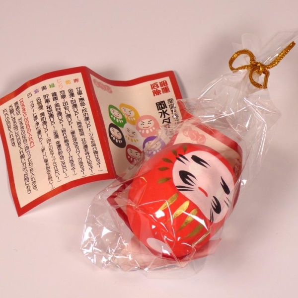 Red mini Daruma doll in wrapping