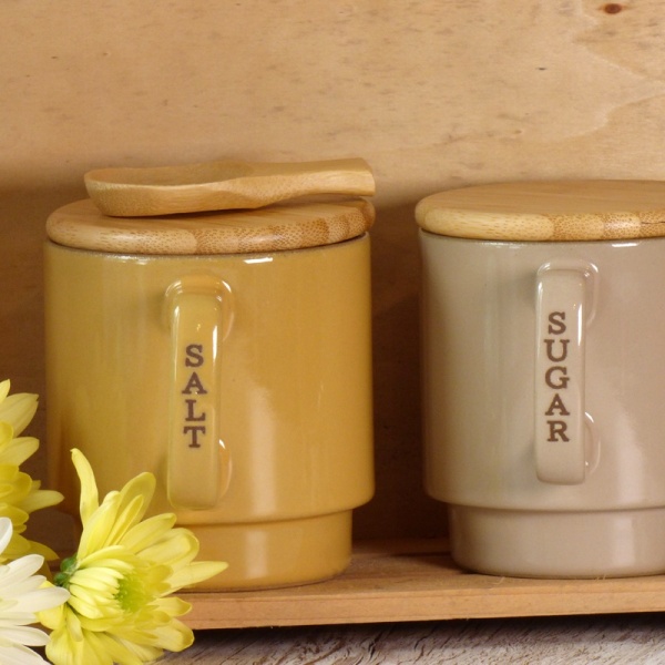 Ceramic salt and sugar storage containers on kitchen shelf