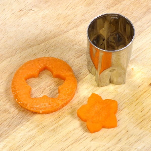 Japanese stainless steel food cutter used to cut a shape from carrot