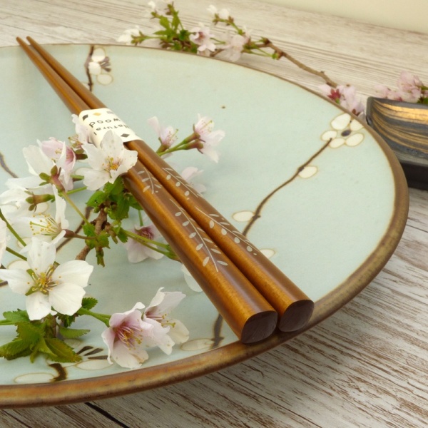 Light oak tone natural wood Japanese chopsticks on plum blossom plate