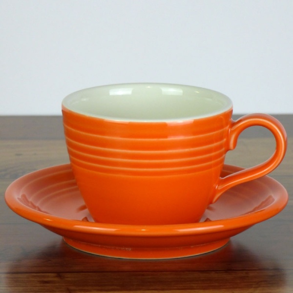 Mandarin orange coffee cup and saucer on wood work surface