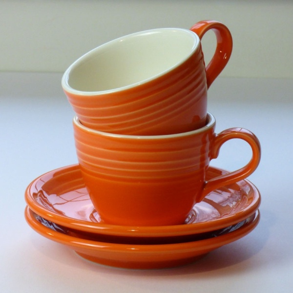 Stack of Mandarin orange coffee cups and saucers