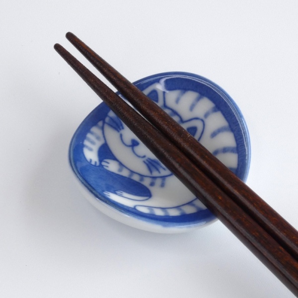 Close up of tabby cat chopstick rest with chopsticks