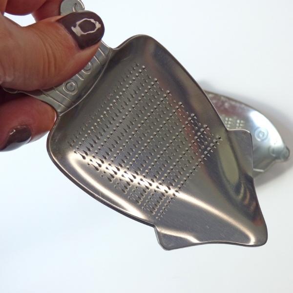 Mini stainless steel grater held in hand