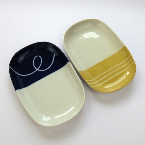 Oval plates, one with navy blue dipped glaze and the other with yellow dipped glaze design