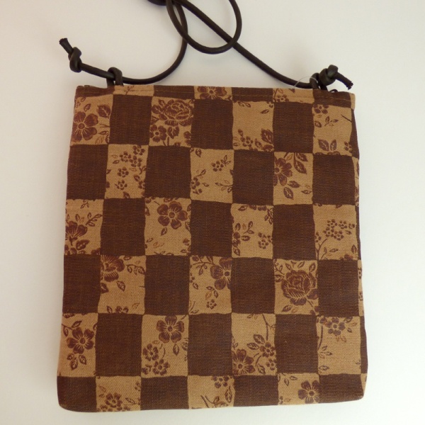 Pochette style handbag in tan and dark brown with a check design