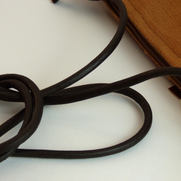 Strap of Pochette style handbag in tan and dark brown with a check design