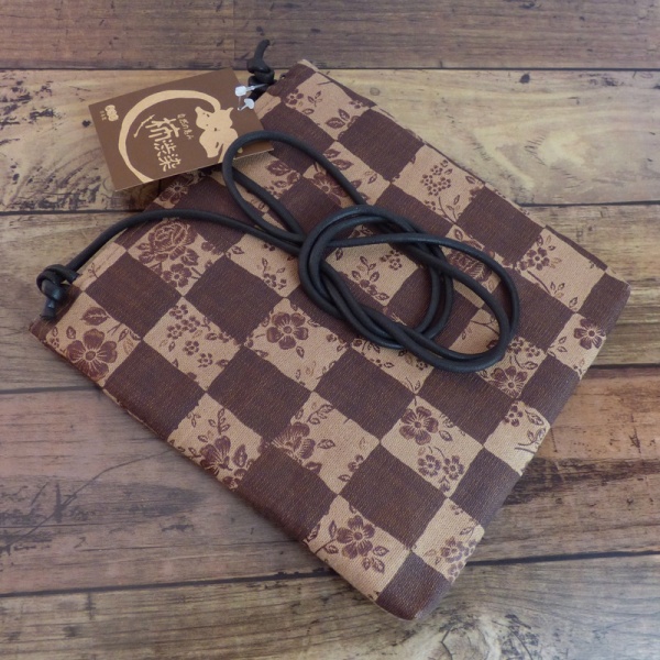 Pochette style handbag in tan and dark brown with a check design