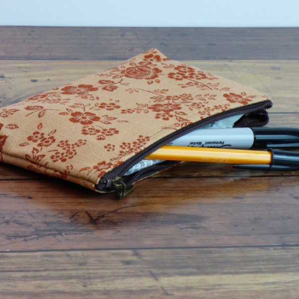 Canvas zip bag with floral design in use as a pencil case