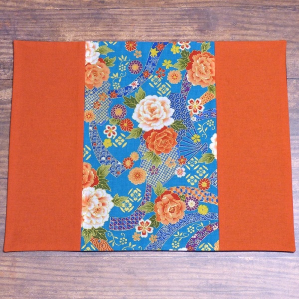 Japanese fabric placemat with orange and turquoise floral design