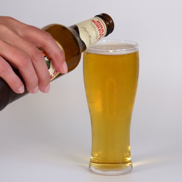Pouring bottled beer into slim Japanese beer glass