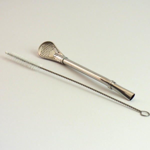 Silver metal straw next to cleaning brush