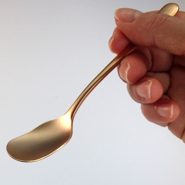 Rose gold sundae and ice cream spoon held in hand