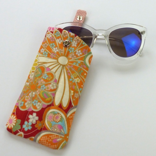 Sunglasses case in red traditional Japanese floral fabric with sunglasses inserted