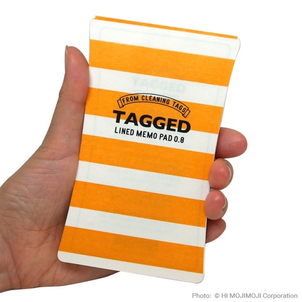 'Tagged' Japanese notepad with Yellow Stripe cover held in hand