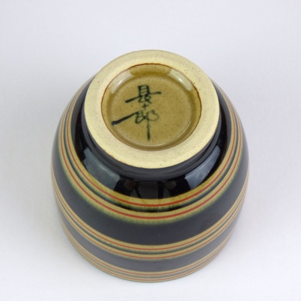 Black Japanese tea cup with red stripe pattern underside
