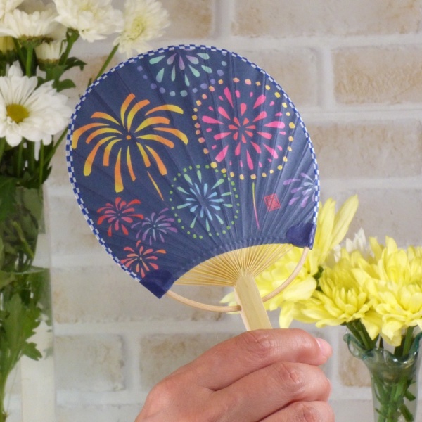 Fireworks design Japanese fan held in hand