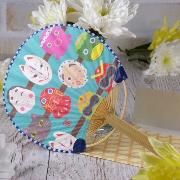 Traditional round Japanese fan with masks design in summery table setting