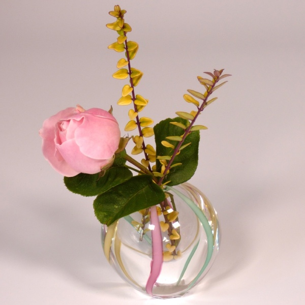Small glass vase with colourful ribbons, with mini ikebana arrangement