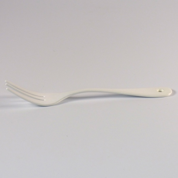 Profile view of white enamel cake fork