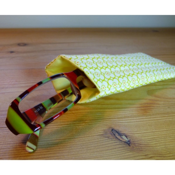 Handmade quilted glasses case in a yellow geometric print - shown with glasses