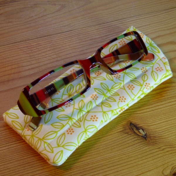 Handmade quilted glasses case in yellow leaf print - shown with glasses