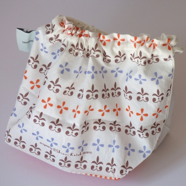 Reverse side of cotton bag featuring heraldic fleur de lis pattern