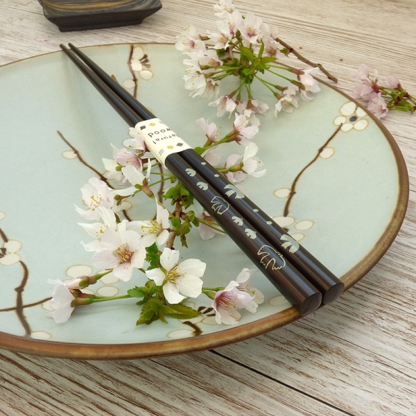Dark wood Japanese chopsticks on plum blossom plate
