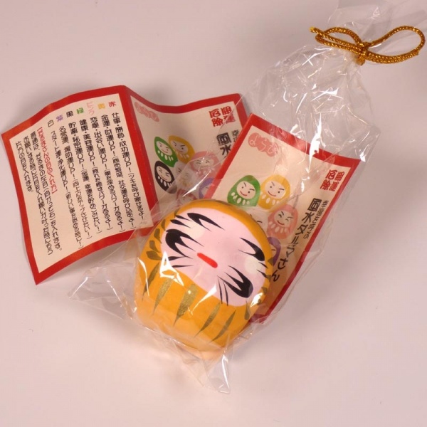Mini traditional Japanese Daruma doll in yellow