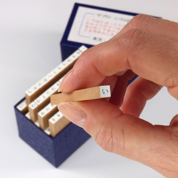 Japanese hiragana craft stamp held in fingers