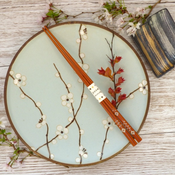 Natural wood flower pattern Japanese chopsticks on blue plate