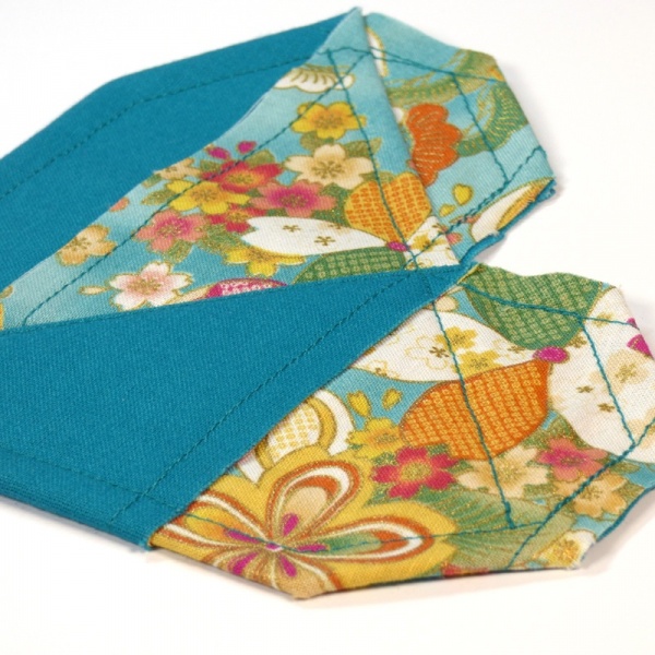 Close up of Japanese fabric heart shaped coaster in turquoise design