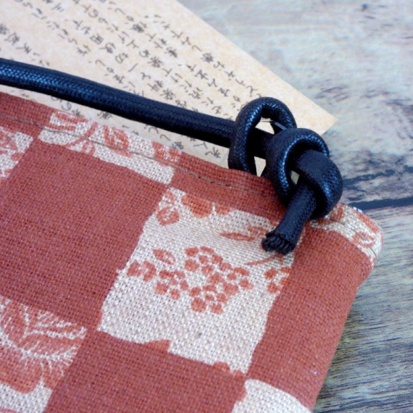 Close up of canvas handbag in brick orange with a check design